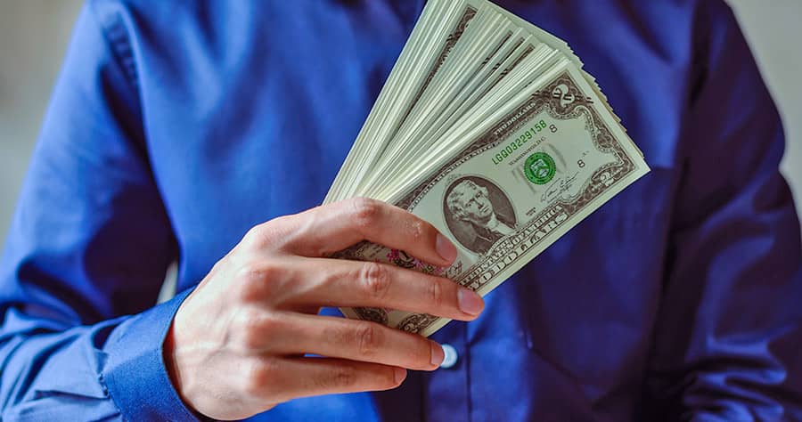 Person Holding a Stack of Dollar Bills Person Holding a Stack of Dollar Bills